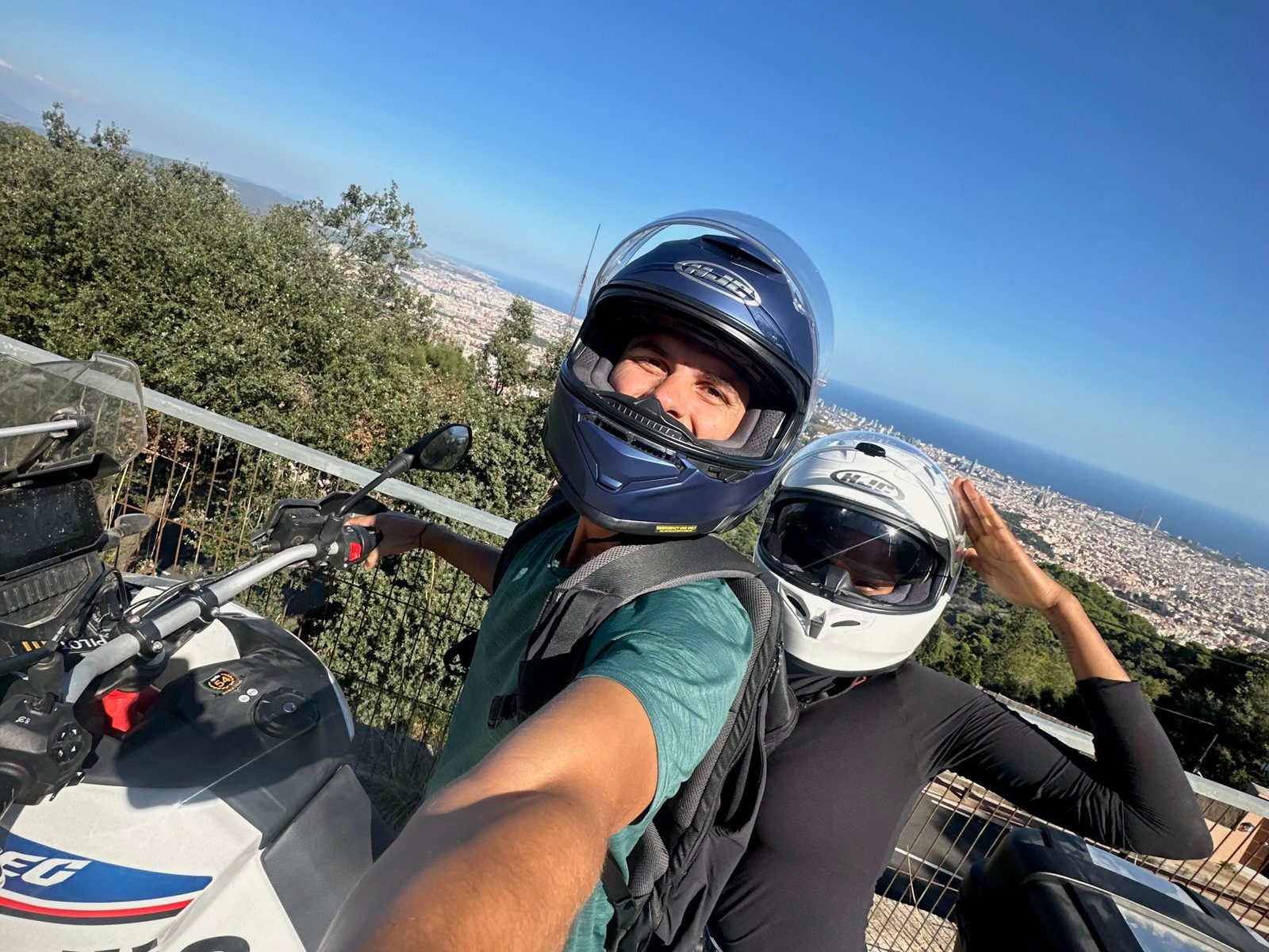 Rider and passenger at a viewpoint high above Barcelona and the sea