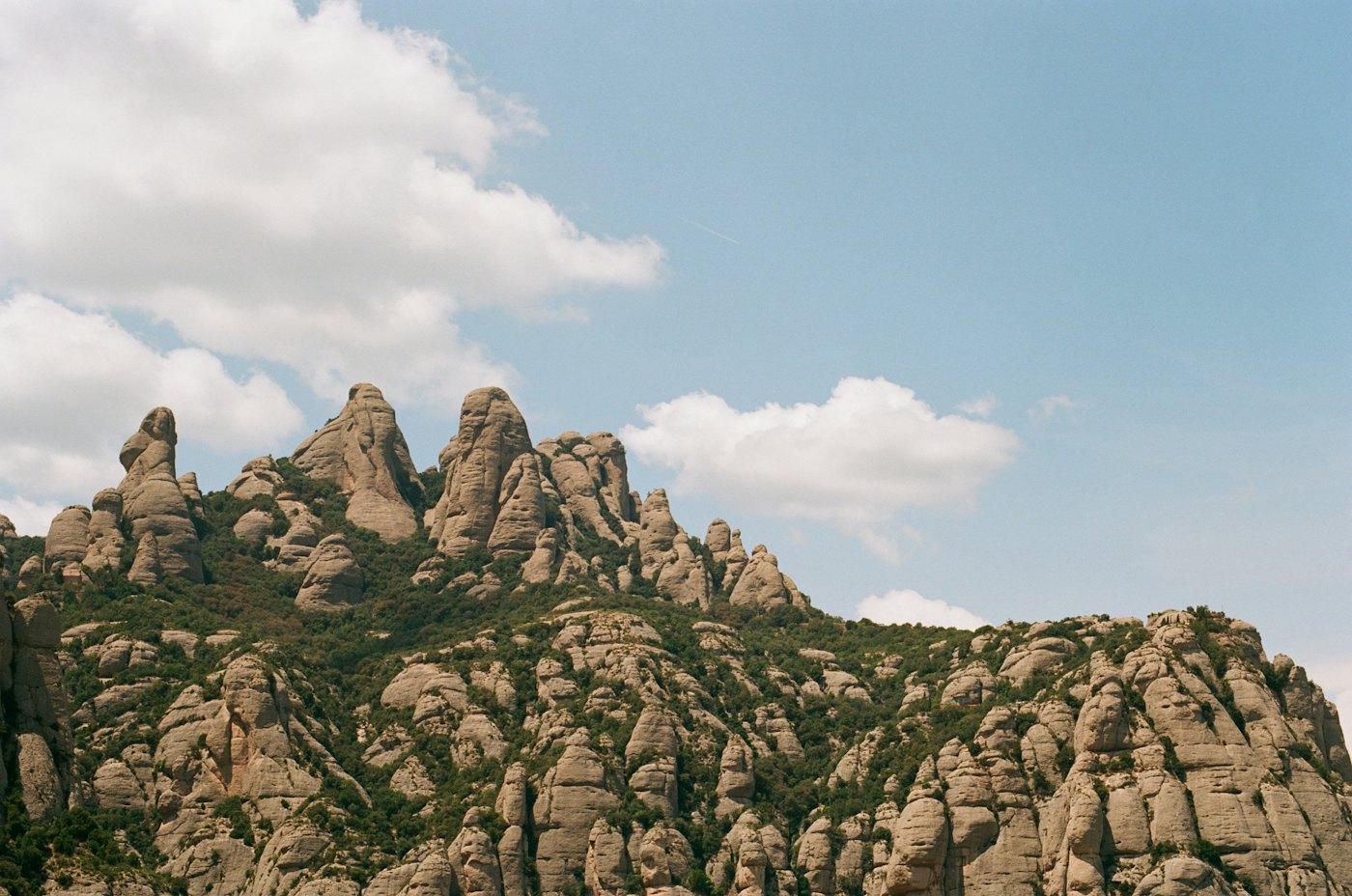 The jagged rock peaks of Montserrat under a blue sky