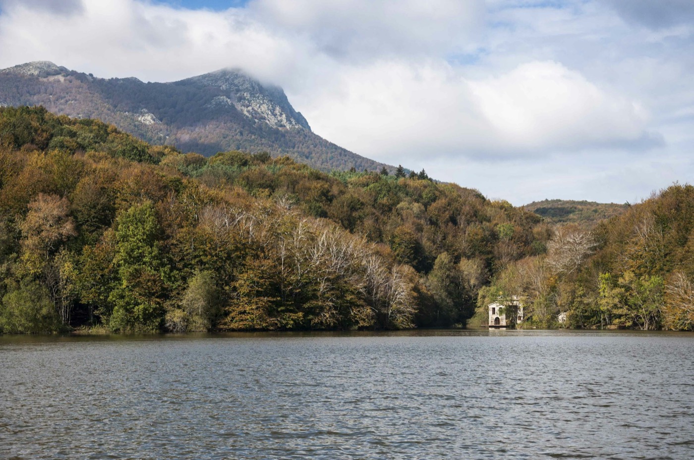 The lake of Santa Fe del Montseny, autumn forest and the Turó de l'Home behind