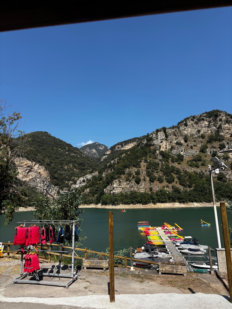 Life vests drying on the pier, the lake and the mountains behind