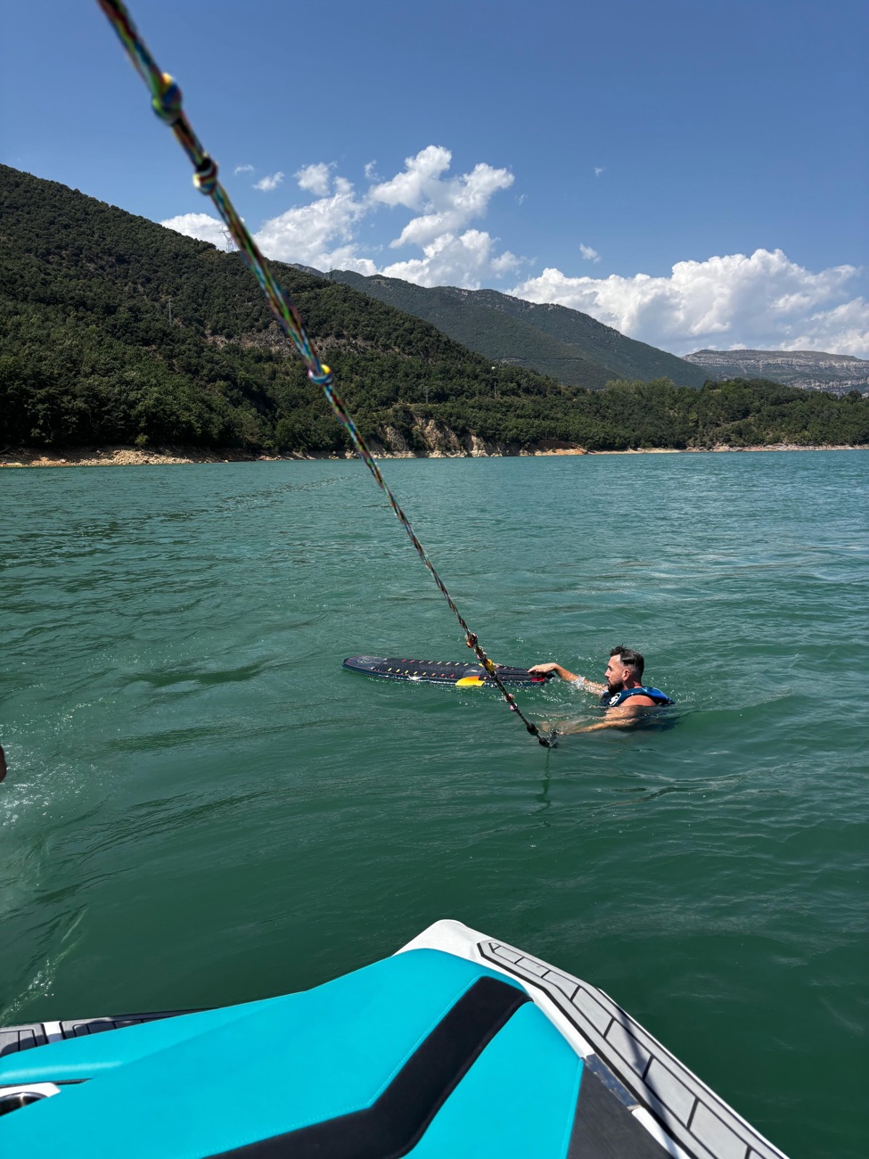 Gabriel in the water with his wakeboard, waiting for the boat to pull
