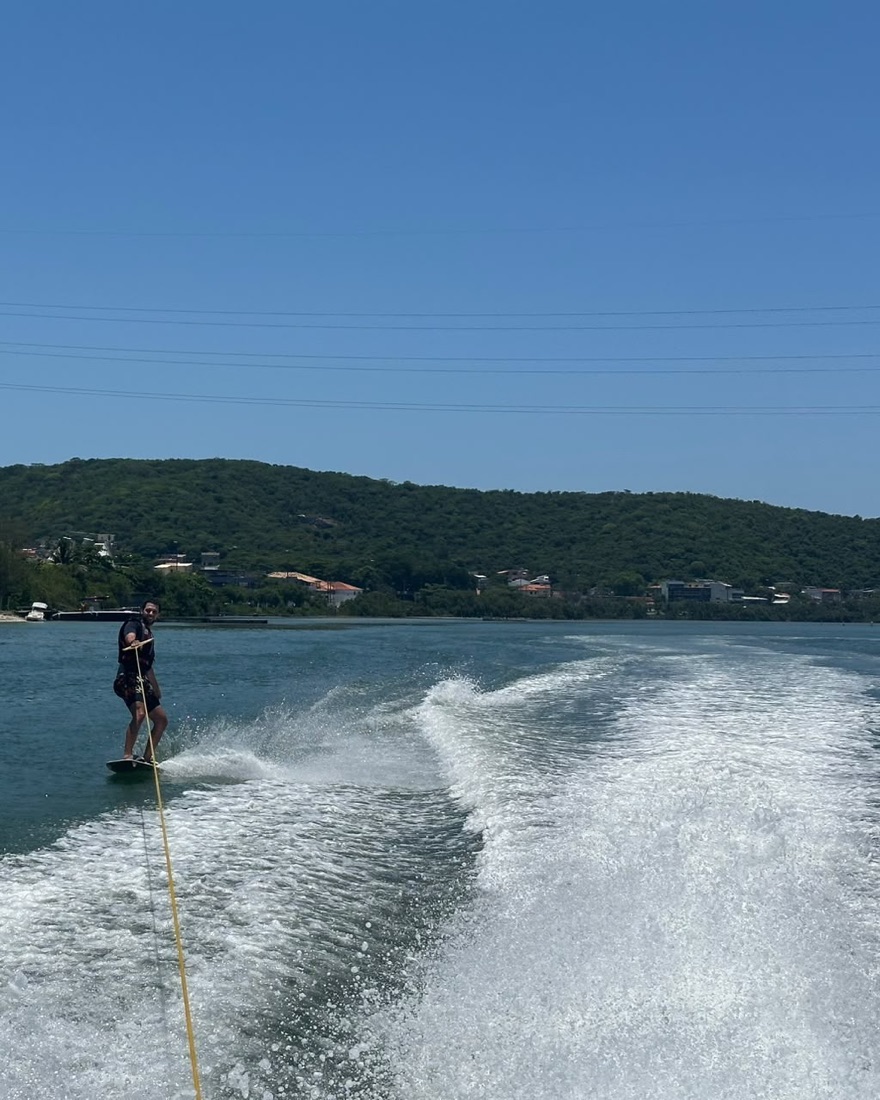 The white wake behind the boat and a wakeboarder