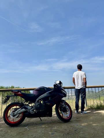 Sport motorcycle at a railing overlooking Barcelona from the Collserola hills