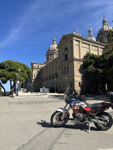 Adventure motorcycle parked in front of the National Art Museum of Catalonia on Montjuïc, Barcelona