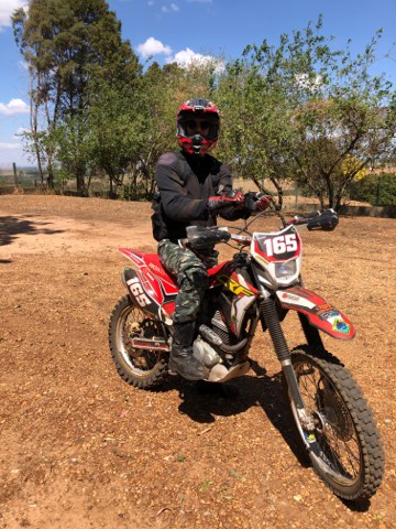 Fahrer auf einer roten Enduro auf einer Erdpiste im Inneren Brasiliens
