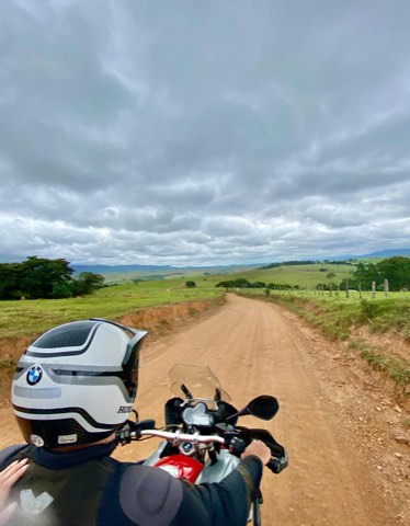 Trail sur une piste de terre rouge à Carrancas, Minas Gerais, sous un ciel d'orage