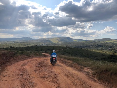 Pilote sur une piste de terre au-dessus d'une large vallée dans la région de Carrancas