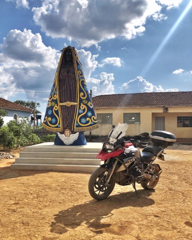 Oratoire au bord de la route à côté d'une moto garée sur une route secondaire du Minas Gerais