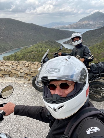 Two riders at a viewpoint above a river valley in Morocco