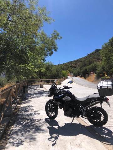 Motorcycle with panniers on a shaded country lane in Andalusia, southern Spain