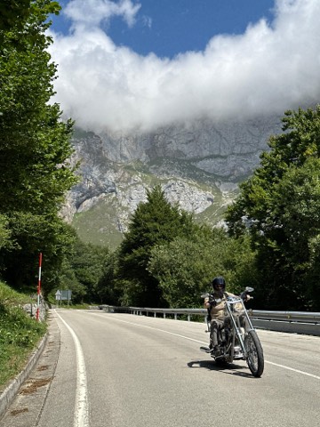 Chopper on a gorge road below a wall of grey limestone in the Picos de Europa