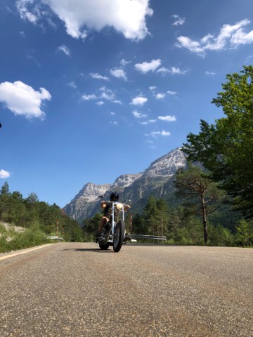 Motorrad auf einer Bergstraße unter zerklüfteten Gipfeln im Aran-Tal