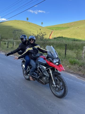 Pilot and passenger on a red adventure motorcycle on a country road outside Rio de Janeiro