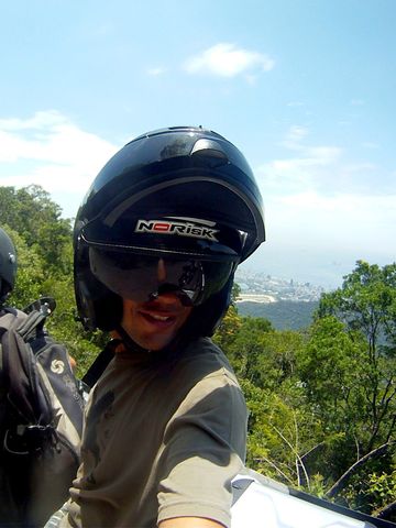 Pilot and passenger on a motorcycle on a forest road above Rio de Janeiro