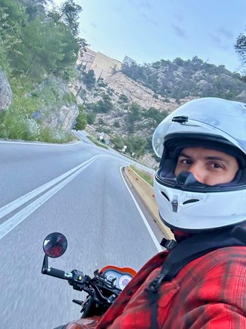 Rider in a white helmet on a curve of the Garraf coast road