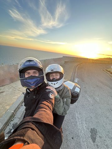 Two people on a motorcycle at a viewpoint on the coast south of Barcelona