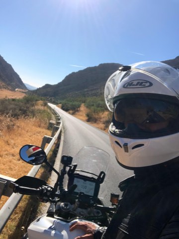 Rider's view along a road cut into the hillside in the Andalusian sierras