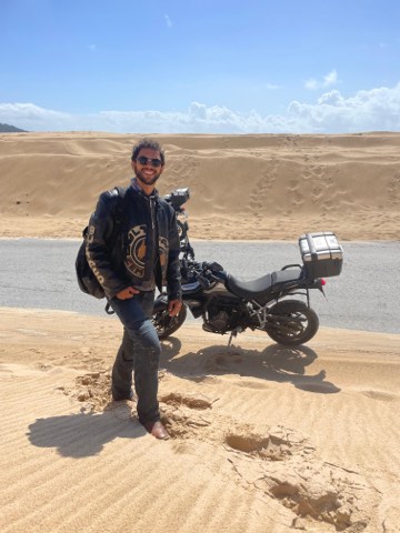 Rider beside a loaded motorcycle on the dunes at Punta Paloma, Tarifa