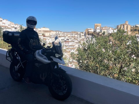 Rider at a viewpoint above a whitewashed hill town in southern Spain