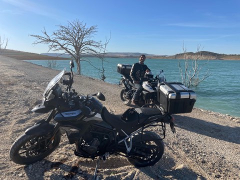 Motorcycles beside a turquoise reservoir in southern Spain
