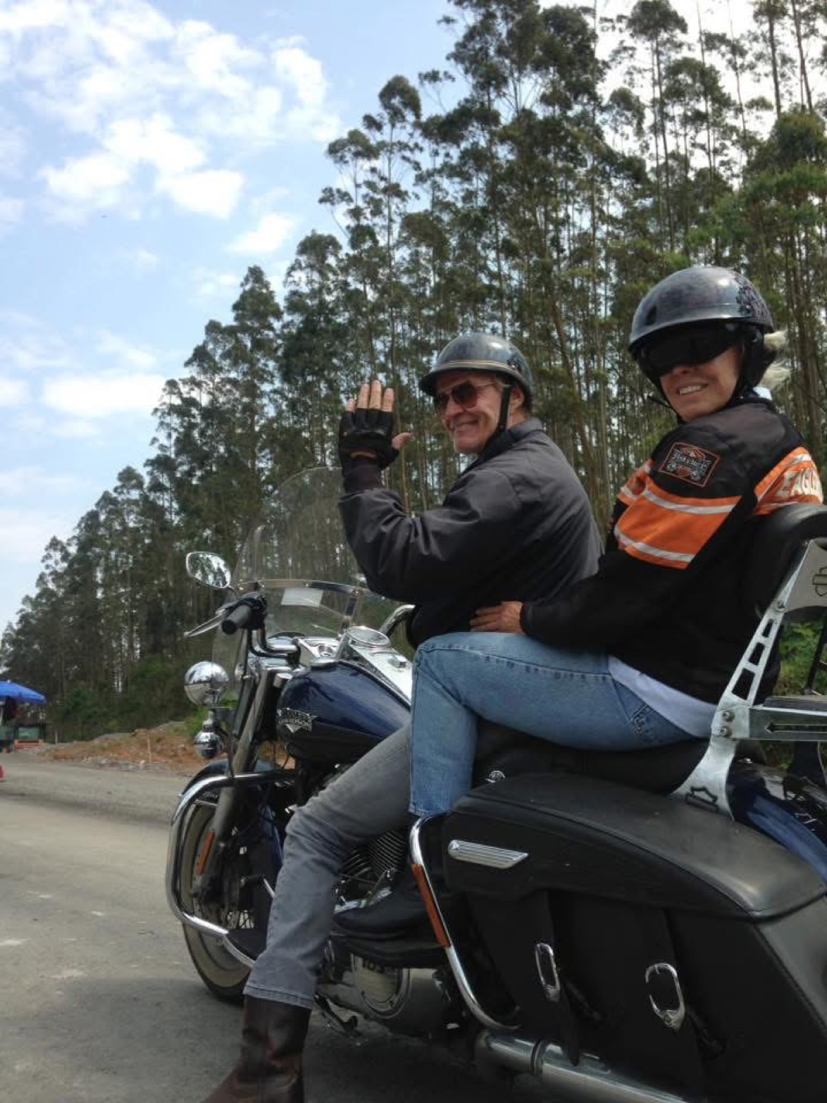 Pilot und Sozius winken von einem Tourenmotorrad